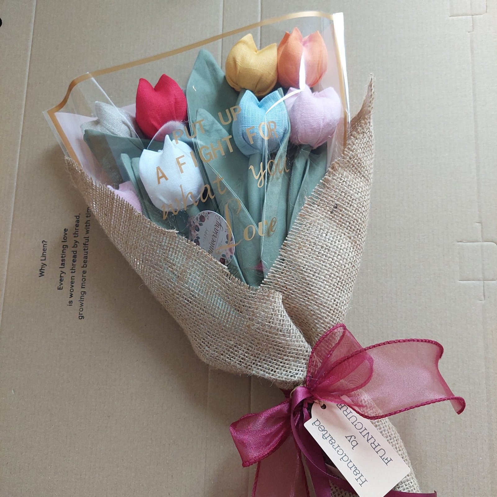 A colourful handmade fabric tulip bouquet wrapped with ribbon and a Furnicure tag